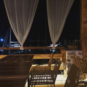 a patio with two chairs and a table with curtains at Blue Sky Aparts in Livadia