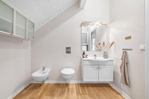 La salle de bains blanche est pourvue de toilettes et d'un lavabo. dans l'établissement Utsikten, à Frøya