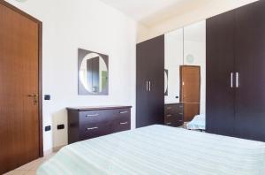 - une chambre avec un grand lit et un miroir dans l'établissement Cozy 55-m2 flat close to the countryside in Narni, à Narni
