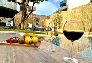 two glasses of wine sitting on a table with fruit at Seaview Grand - VILLA SUNRISE in Marmaris