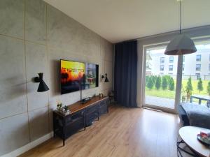 a living room with a couch and a tv on a wall at Nadmorski apartament premium in Gdynia