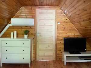 a small attic room with a door and a television at Domek letniskowy Sosenka in Woryty