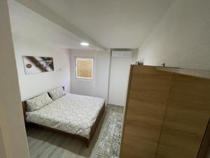 a small bedroom with a bed and a cabinet at Vila 5 in Prilep
