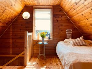 a bedroom with a bed in a wooden cabin at Domek letniskowy Sosenka in Woryty