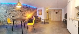 a living room with a table and chairs and a brick wall at La Librairie in Francorchamps