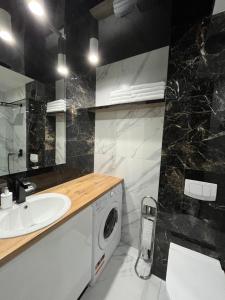 łazienka z pralką i umywalką w obiekcie Apartament MAKEJA w mieście Malbork