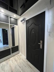 czarne drzwi w pokoju z oknem w obiekcie Apartament MAKEJA w mieście Malbork