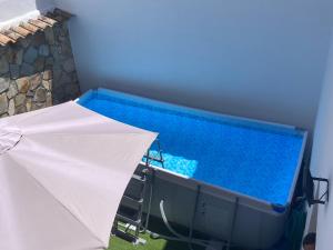 a swimming pool with an umbrella next to it at Casa Rural Abuelo Teo in Campo de Criptana