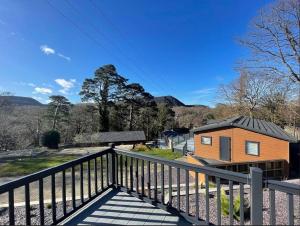 a small house with a black roof on a balcony at C05 - The Ogwen Lodge with Hot Tub in Bethesda