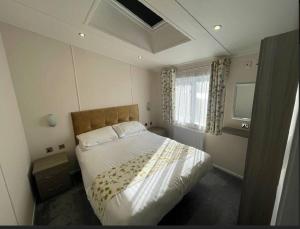 een slaapkamer met een bed en een raam bij C05 - The Ogwen Lodge with Hot Tub in Bethesda