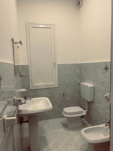 a bathroom with a sink and a toilet and a mirror at Casa Vacanza Elena in Capo dʼOrlando