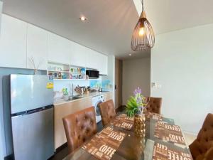 a kitchen with a dining table and a refrigerator at Veranda Residences Pattaya By Phung in Jomtien Beach