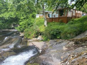 a house on a hill next to a river at V13 - The Falls with Hot Tub in Bethesda