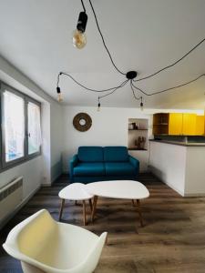 a living room with a blue couch and a table at Appartement dans le quartier recherché du mouré in Collioure