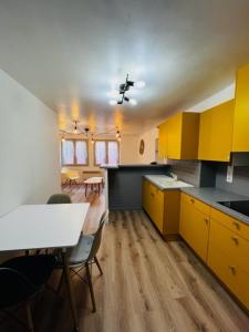 a kitchen with yellow cabinets and a table and chairs at Appartement dans le quartier recherché du mouré in Collioure