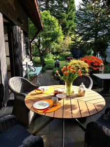 una mesa de madera con un jarrón de flores en el patio en Ferienhaus Moselgrün en Cochem