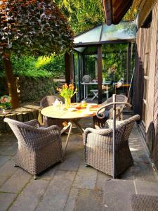 um pátio com uma mesa e 2 cadeiras e uma mesa e cadeiras em Ferienhaus Moselgrün em Cochem