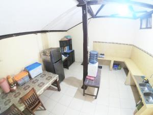 a view of a kitchen with a table and a refrigerator at Joglo Sempu Homestay in Bedoyo
