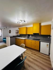 a kitchen with yellow cabinets and a table with chairs at Appartement dans le quartier recherché du mouré in Collioure