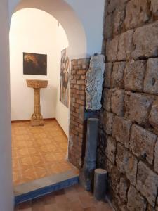a room with a stone wall and a sculpture at Foresteria in Tuscania