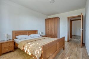 1 dormitorio con 1 cama grande y armario de madera en Old stone villa Vrba en Sveti Stefan