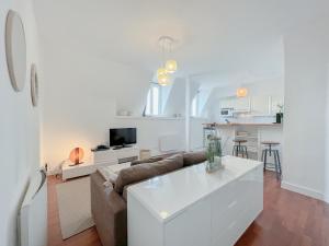 Sala de estar blanca con sofá y mesa en Appart Hypercentre - Le Clemenceau, en Burdeos