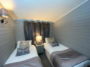 two twin beds in a room with a window at L09 - The Snowdon Spa with Hot Tub in Bethesda