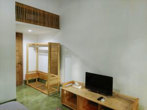 a living room with a television on a wooden table at Komoreya Guesthouse in Yogyakarta