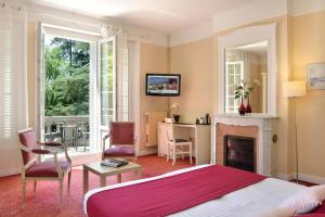 1 dormitorio con 1 cama y chimenea en Logis Hôtel Restaurant Le Parc en Salbris