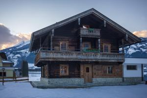 a log cabin in the snow in front of a mountain at Chalet Fasserhäusl in Finsing