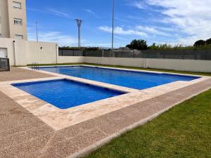 a swimming pool with blue water in a yard at Penthouse panoramic sea view in Oliva