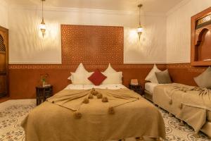 a bedroom with two beds in a room at Riad Dar Yema in Marrakech