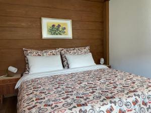 une chambre avec un grand lit avec une tête de lit en bois dans l'établissement Villa Maria Dolomites Vintage Home, à Brunico