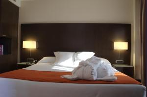 A bed or beds in a room at Hotel Zenit Pamplona