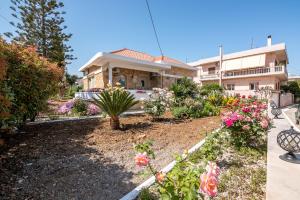 a house with a garden with flowers in front of it at Harmony House in Kissamos