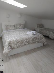 a white bedroom with a bed and a couch at Isaura Home in Peniche