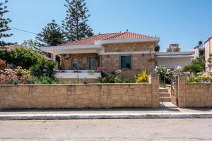 una casa con una recinzione di pietra di fronte di Harmony House a Kíssamos