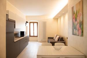 un piccolo soggiorno con divano e cucina di Flower Apartments a Bardolino