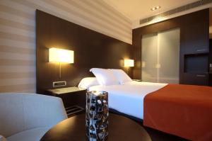 A bed or beds in a room at Hotel Zenit Pamplona