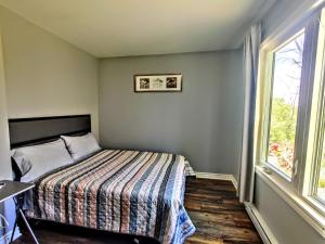 a small bedroom with a bed and a window at Salmon River Motel in Shannonville