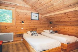 1 dormitorio con 2 camas en una cabaña de madera en Chalet Melezor, en Saint-Chaffrey