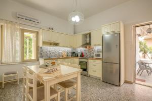 a kitchen with a table and a refrigerator at Harmony House in Kissamos