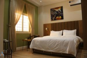 a bedroom with a large bed and a window at شقق لمسات الخير الخيالة للشقق المخدومةAh in Riyadh