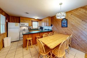 a kitchen with a wooden table and a white refrigerator at The Sea Salt Cottage at Geri's Place 304 in Nags Head
