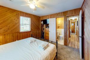 a bedroom with wooden walls and a bed with a ceiling fan at The Sea Salt Cottage at Geri's Place 304 in Nags Head