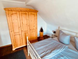 1 dormitorio con 1 cama y armario de madera en Ferienwohnung Ernzerhof, en Idar-Oberstein