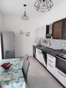 a kitchen with a table with chairs and a refrigerator at Villa Anna Maria in Polignano a Mare