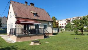 ein Haus mit einem roten Dach und einem grünen Hof in der Unterkunft Ferienhaus Käthe in Klagenfurt am Wörthersee