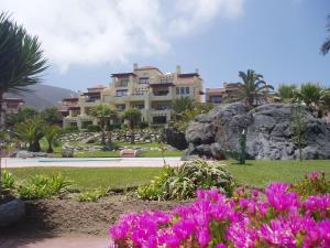 a large building in the middle of a park with flowers at Norus Las Tacas in Las Tacas