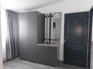 a room with a black cabinet and a mirror at La Maria in Şuncuiuş